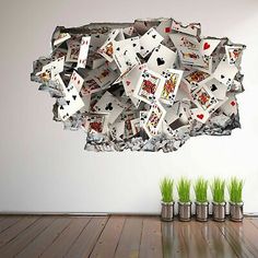 a wall mounted on the side of a room with playing cards falling out of it