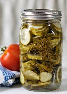 a glass jar filled with pickles and lemon slices