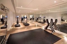 an exercise room with treadmills and mirrors