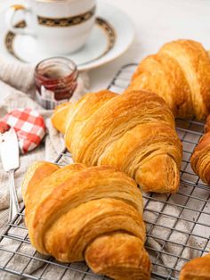 croissants on a cooling rack next to a cup and saucer