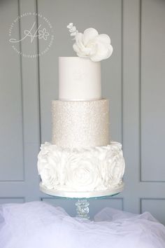 a three tiered wedding cake with white flowers on top