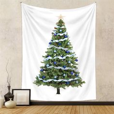 a christmas tree with blue and white ornaments hanging on a wall in front of a wooden floor