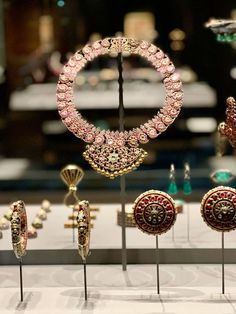 an assortment of jewelry on display in a glass case