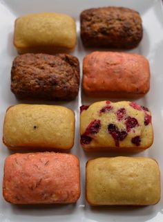 nine different types of pastries sitting on a white plate with red and yellow toppings