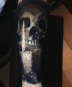 a black and white photo of a skull on someone's arm with water coming out of it