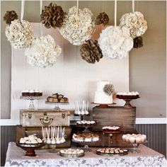 dessert table with cake, cookies and cupcakes on wooden trays hanging from the ceiling