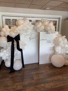 balloon arch with black ribbon and white balloons