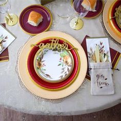 the table is set with plates, napkins and place settings for an autumn themed dinner