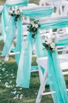 rows of white chairs with blue sashes and flowers