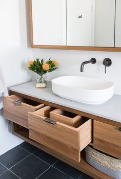 a bathroom with a sink, mirror and drawers