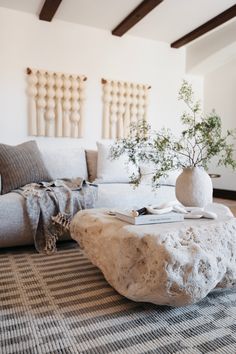 a living room filled with furniture and a large stone coffee table on top of a rug