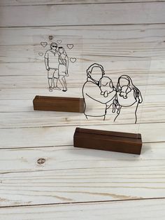 two clear acrylic stamps with a couple holding each other on top of a wooden stand