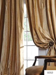 a chair sitting in front of a window covered in curtains