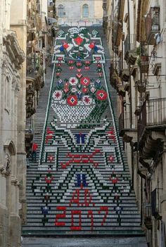 an elaborately decorated staircase in the middle of a city with lots of flowers on it