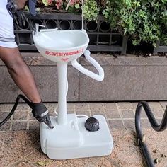 a man is using a machine to clean a flower pot