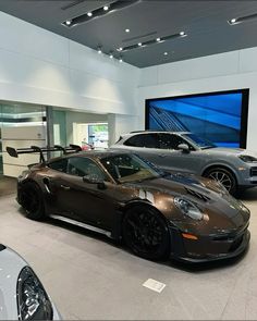 two sports cars are parked in a showroom