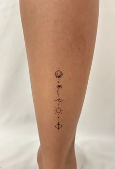 a woman's leg with an anchor, flower and compass tattoo on the side