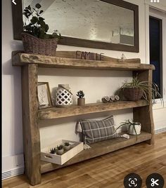 a wooden shelf sitting on top of a hard wood floor next to a mirror and potted plant