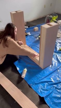 a woman is laying on the floor with some wood