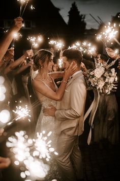 a bride and groom are surrounded by sparklers