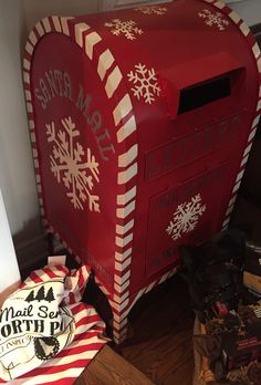 a red mailbox sitting on top of a wooden floor next to a pile of boxes