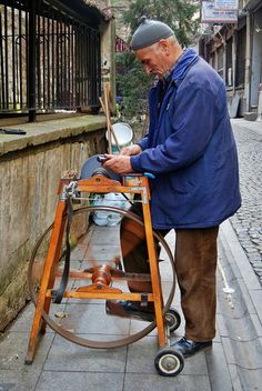 an older man is working on something outside