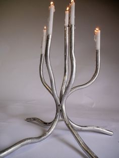 a group of candles that are on some kind of metal stand with one candle in the middle