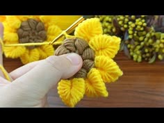 someone is knitting flowers with yellow yarn