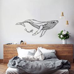 a bedroom with a bed and a wall sticker on the wall that has a drawing of a whale in it