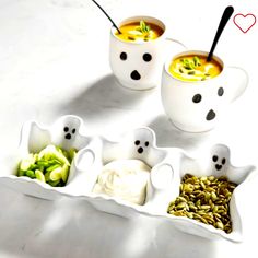 three white cups filled with soup and vegetables