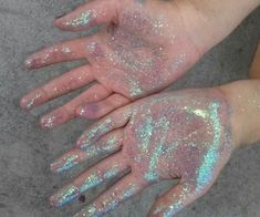 two hands are covered with holographic powder