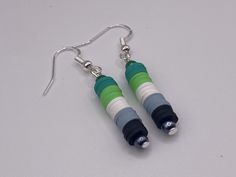 Proudly show your true colors all year round with these stunning Aromantic Pride earrings. Crafted from vibrant clay disks in the iconic Green, White, Gray, and Black flag colors, these earrings are a bold statement of your identity. - Made from high-quality clay disks in the Aro colors - Silver-colored hooks for a sleek, modern look - Lightweight and comfortable to wear all day - Unique piece of LGBTQ+ jewelry to express your identity Whether you're part of the Aromantic community, or are looki Lgbtq Jewelry, Pride Earrings, Disk Earrings, Pride Colors, Buddha Pendant, Black Flag, Disc Earrings, Themed Jewelry, Flag Colors