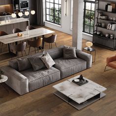 a living room filled with furniture next to a kitchen and dining room table in front of a window