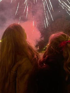 two girls looking at fireworks in the sky