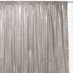 a silver curtain hanging on the side of a brick wall