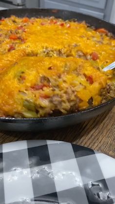 a skillet filled with food sitting on top of a wooden table