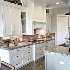 a large kitchen with white cabinets and marble counter tops is pictured in this image from the front view