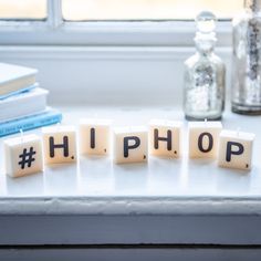 the word hip hop spelled out with scrabble blocks in front of a window