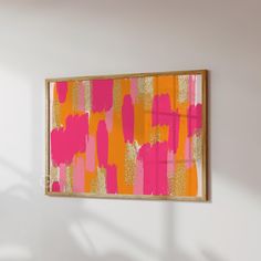 a pink and orange painting hanging on the wall