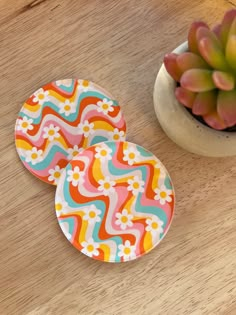 two plates sitting on top of a wooden table next to a potted succulent