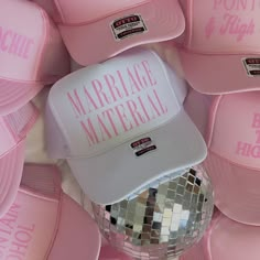 a pink hat with the words marriage material printed on it and disco ball in front