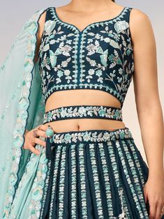 This stunning ensemble features a teal blue color satin lehenga with intricate sequin and coding thread embroidered work, paired with a matching satin choli adorned with the same exquisite details. The look is completed with a sky-blue georgette dupatta featuring a sequin work ethnic motif and embroidery cut work border.
The teal blue lehenga is semi-stitched up to 42 inches with a 3.0-meter flair, allowing for a perfect fit. The un-stitched choli material gives you the freedom to customize the Blue Palazzo Set With Intricate Embroidery For Diwali, Blue Embroidered Palazzo Set For Diwali, Blue Anarkali Palazzo Set With Intricate Embroidery, Blue Chinon Set For Navratri, Blue Chinon Sets For Navratri, Blue Mirror Work Choli In Dola Silk, Blue Mirror Work Dola Silk Choli, Blue Dola Silk Lehenga With Mirror Work, Designer Embroidered Turquoise Lehenga