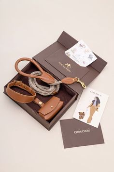 an open brown box containing a purse and some cards