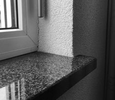 a black and white photo of a window sill next to a counter with a sink