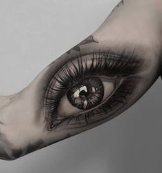 an eye is shown on the arm and it's black and white tattoo design