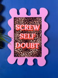 a sign that says screw selfie doubt on the side of a blue wall next to a potted plant