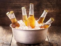 several bottles of beer are in an ice bucket