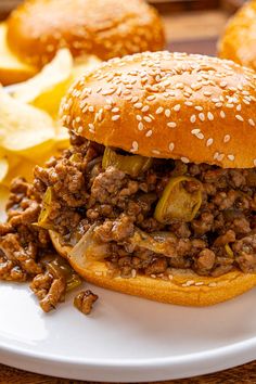 a sloppy joe sandwich on a plate with potato wedges