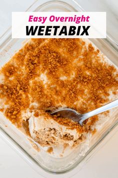 a bowl filled with food sitting on top of a white table next to a spoon