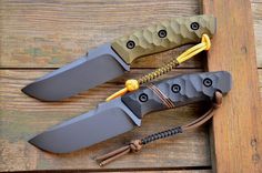 two knives are sitting next to each other on a wooden surface, one is green and the other is yellow